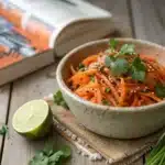 Raw carrot salad in bowl with parsley